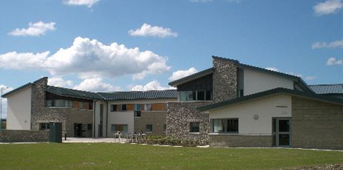 a large brick building with grass in front of a house